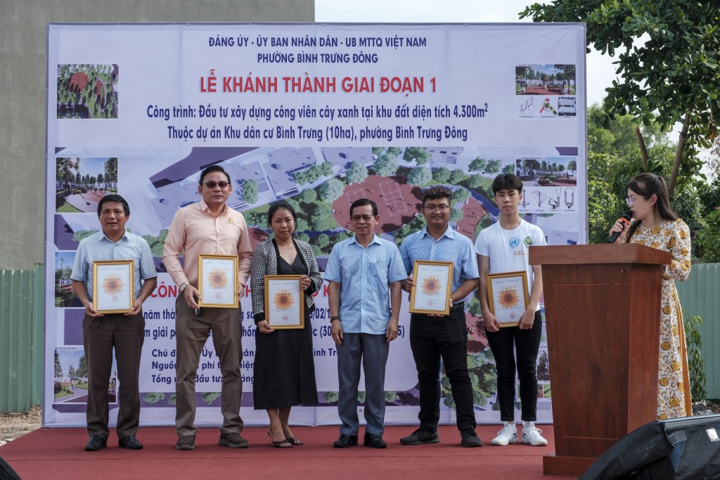 Oscar Vũ (ngoài cùng bên phải) nhận thư cảm ơn của UBND phường Bình Trưng Đông vì đóng góp xây dựng dự án công viên cây xanh