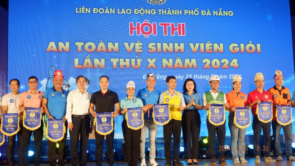 Bà Phan Thị Thùy Linh, Chủ tịch LĐLĐ thành phố Đà Nẵng trao cờ lưu niệm cho các đội thi (Ảnh Đ.Minh)