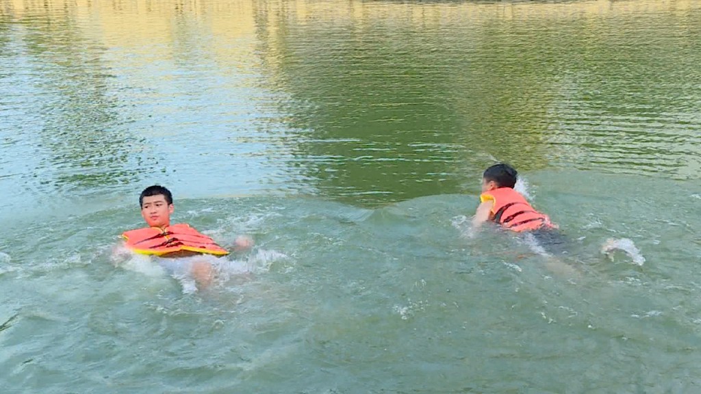 Trẻ nhỏ được trang bị áo phao trước khi xuống tắm, bơi lội tại ao Quan (Gia Lâm, Hà Nội)