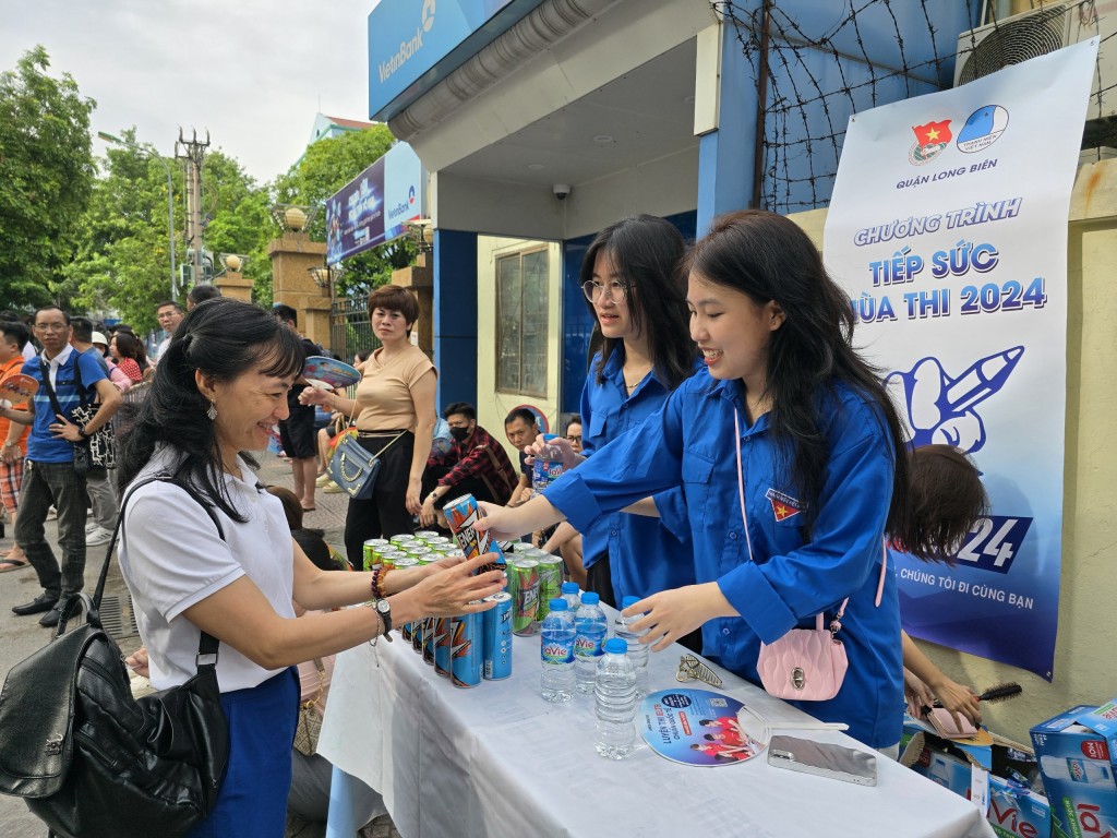 Đội hình Tiếp sức mùa thi tại trường THPT Nguyễn Gia Thiều (Long Biên) tặng nước cho người nhà thí sinh bên ngoài phòng thi