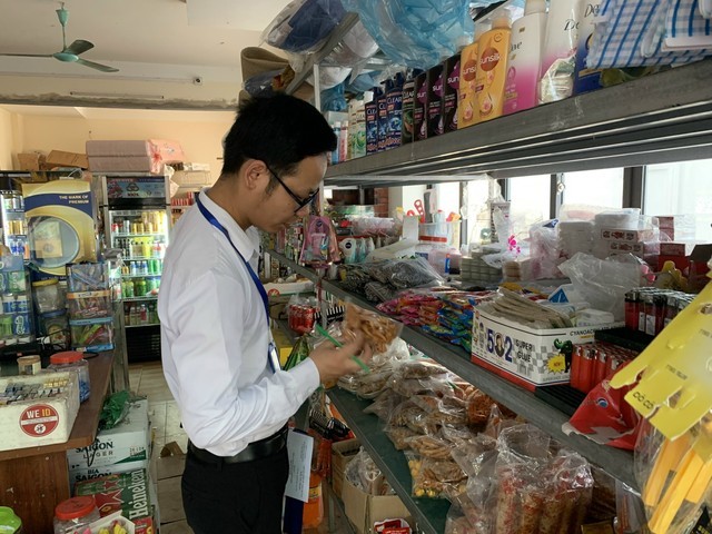 Thành viên Đoàn kiểm tra liên ngành ATTP thị trấn Chi Đông kiểm tra hạn sử dụng của sản phẩm tại cửa hàng tạp hóa. Ảnh: Trịnh Hường