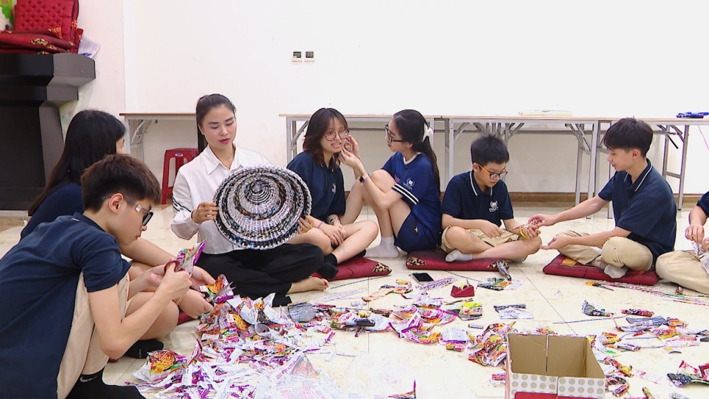 Chị Vũ Thị Thảo hướng dẫn các học trò đan sản phẩm từ những cuộn vỏ mì tôm