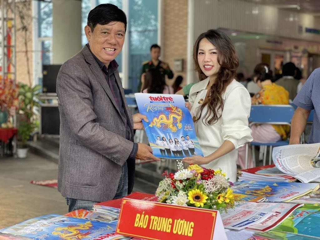 Độc giả Đặng Phi Hoàng (bên trái) bày tỏ vui mừng khi nhận được ấn phẩm đặc biệt xuân Giáp Thìn 2024 từ phóng viên báo Tuổi trẻ Thủ đô