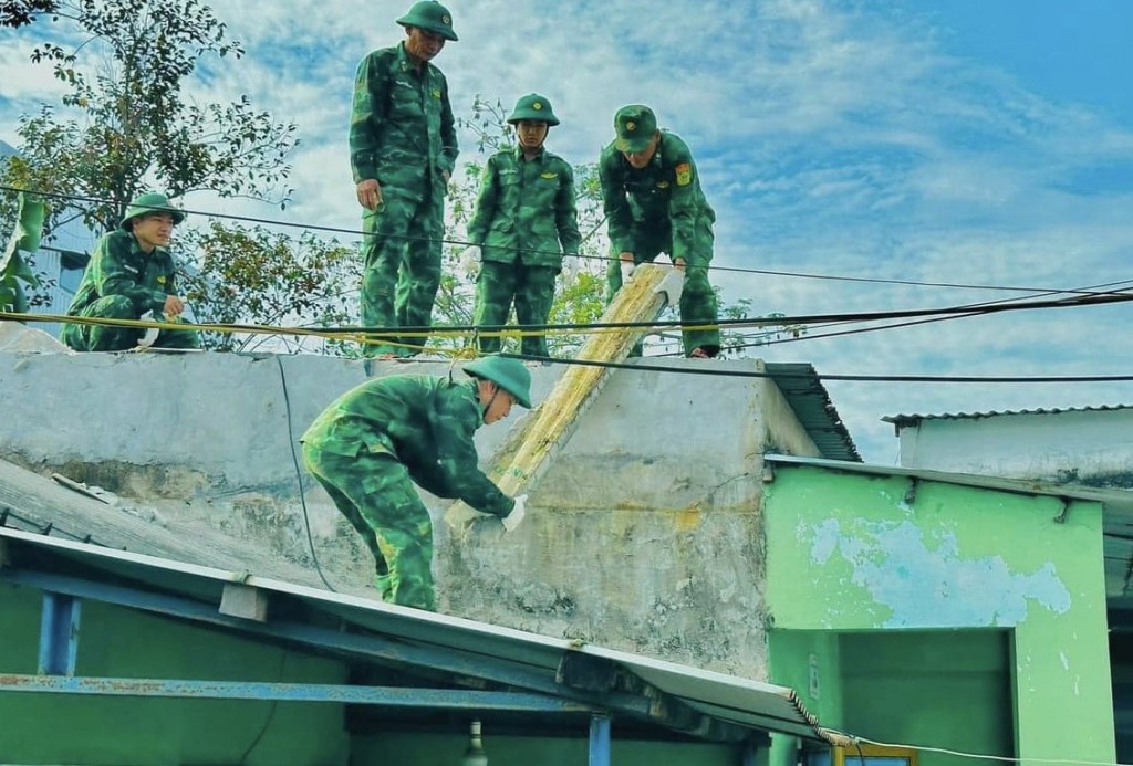 Cán bộ, chiến sĩ Đồn Biên phòng Hải Vân phối hợp đoàn viên thanh niên sửa chữa nhà cho mẹ Lê Thị Tuôi có con là liệt sĩ