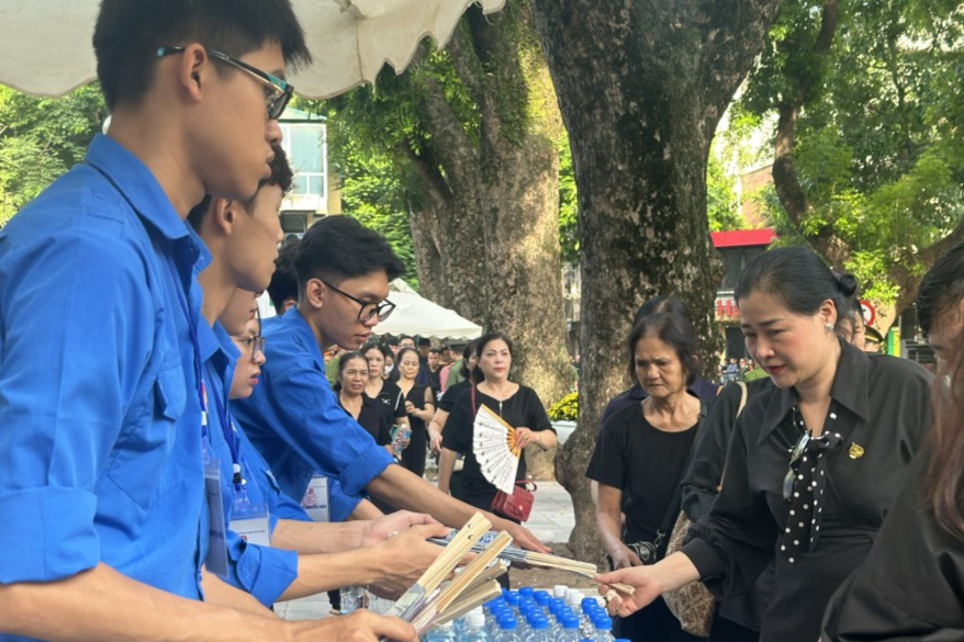 Những chai nước mát, chiếc quạt cầm tay được tình nguyện viên trao cho người dân giúp xua đi nắng nóng 