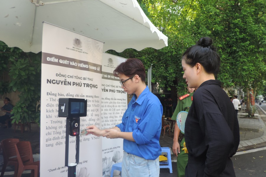Nguyễn Long Vũ hỗ trợ người dân quét mã để vào viếng Tổng Bí thư  Nguyễn Phú Trọng 