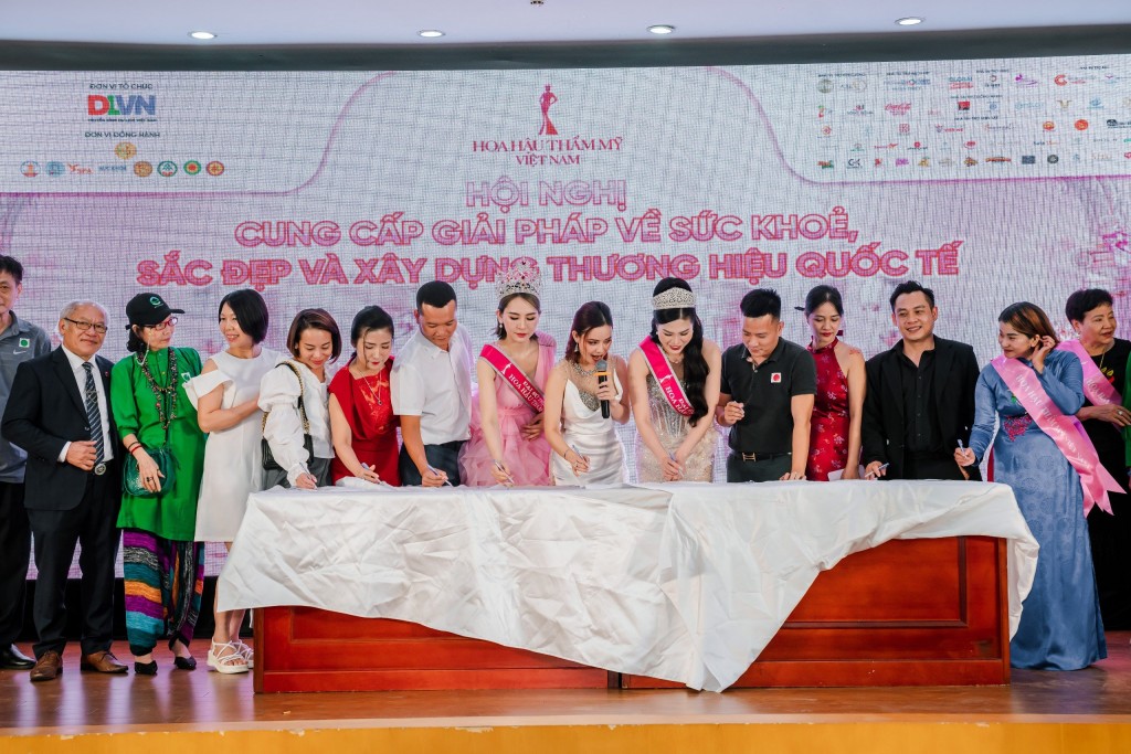 Các khách mời ký lên chiếc áo blouse cam kết chung tay bảo vệ sức khỏe - sắc đẹp cộng đồng Việt Nam