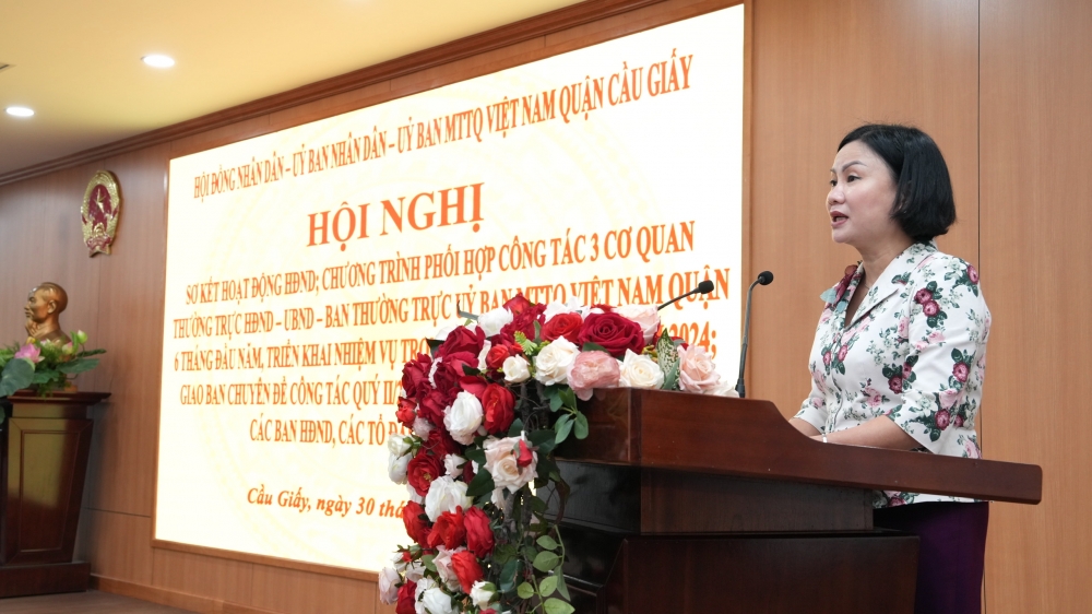 Bà Nguyễn Thị Thanh, Chủ tịch UBMTTQ quận trình bày báo cáo sơ kết 6 tháng đầu năm Chương trình phối hợp công tác năm 2024 giữa Thường trực HĐND quận - UBND - Ban Thường trực UBMTTQ Việt Nam quận.