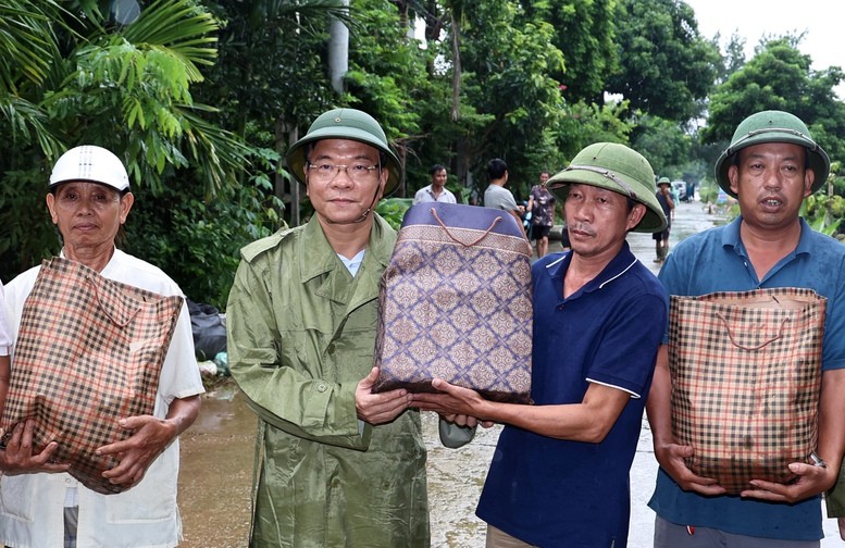 Phó Thủ tướng Lê Thành Long đã hỏi thăm, động viên, chia sẻ với những khó khăn vất vả và tặng quà cho người dân vùng rốn lũ - Ảnh: VGP/Đức Tuân