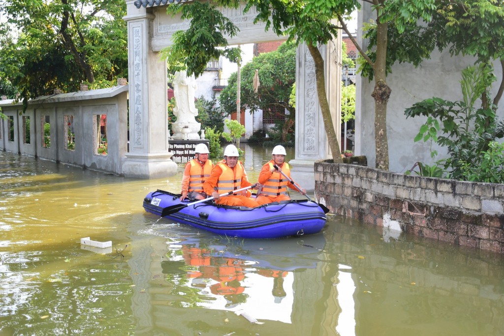 Cán bộ công nhân viên EVNHANOI sử dụng thuyền phao kiểm tra đóng, cắt điện tại vùng ngập úng