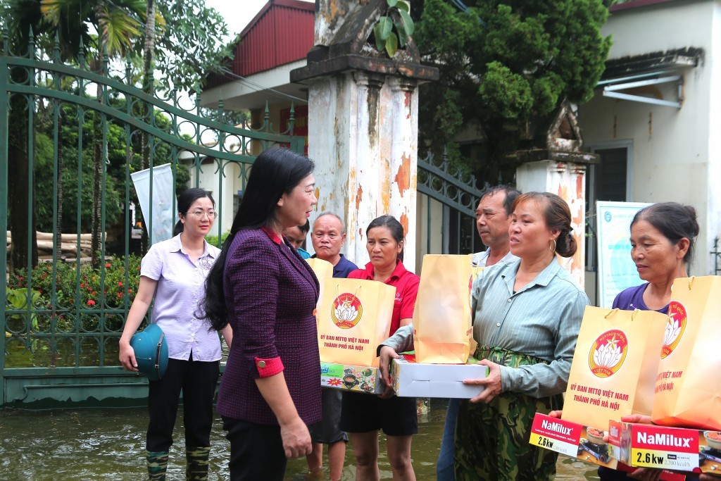 Ủy viên Ban Thường vụ Thành ủy, Chủ tịch Ủy ban MTTQ Việt Nam thành phố Hà Nội Nguyễn Lan Hương tặng quà và động viên bà con nhân dân vùng bị ảnh hưởng