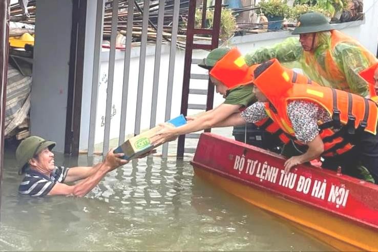 Đoàn công tác của huyện Chương Mỹ đến thăm và tặng quà hỗ trợ người dân vùng úng ngập do ảnh hưởng của bão số 2. Ảnh: Bảo Châu