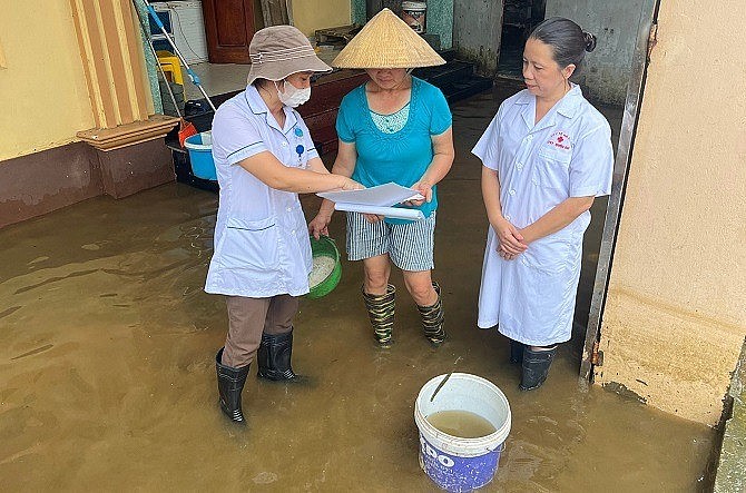 Hướng dẫn người dân vệ sinh môi trường, xử lý nguồn nước tại xã Tuyết Nghĩa, Quốc Oai. Ảnh: TTYT huyện Quốc Oai