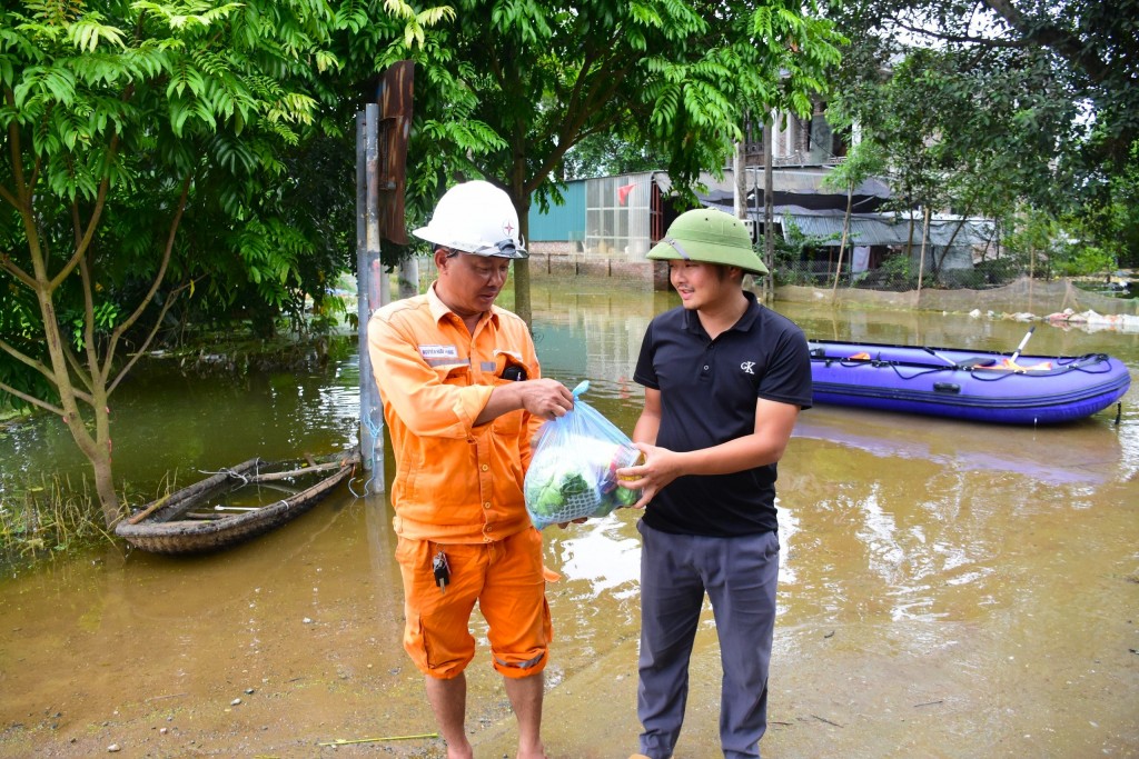 Những người thợ điện cùng chia sẻ khó khăn và  tặng quà cho những người dân vùng ngập lụt nặng