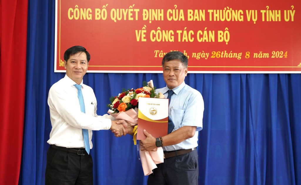 Bí thư Tỉnh ủy Tây Ninh Nguyễn Thành Tâm (trái) trao quyết định và hoa chúc mừng tân Phó Trưởng Ban Tổ chức Tỉnh ủy Lê Anh Tuấn.