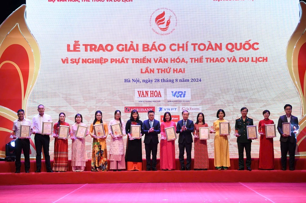 Chủ tịch Hội Nhà báo Việt Nam Lê Quốc Minh, Phó Trưởng Ban thường trực Ban Dân vận Trung ương Phạm Tất Thắng trao giải cho các tác giả, đại diện nhóm tác giả đoạt giải Nhì