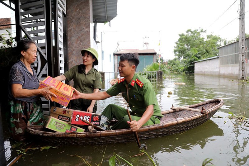 Công an TP Hà Nội bơi thuyền cấp phát nhu yếu phẩm cho người dân bị ngập lụt do nước lũ