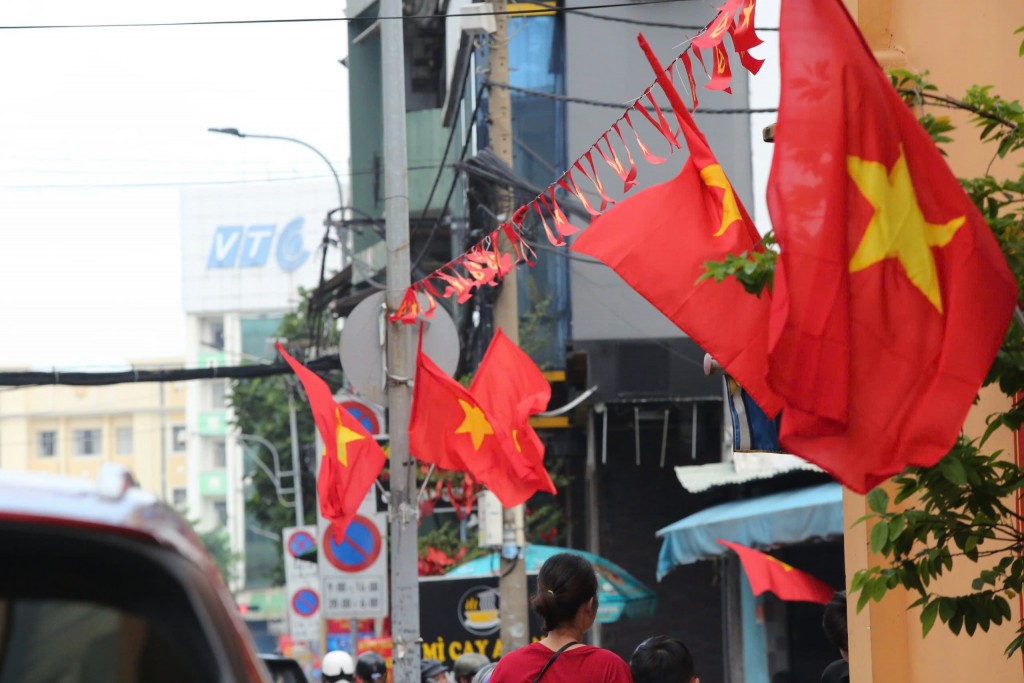 Những lá cờ đổ, sao vàng tung bay dưới gió gợi lên lòng tự hào dân tộc trong người dân