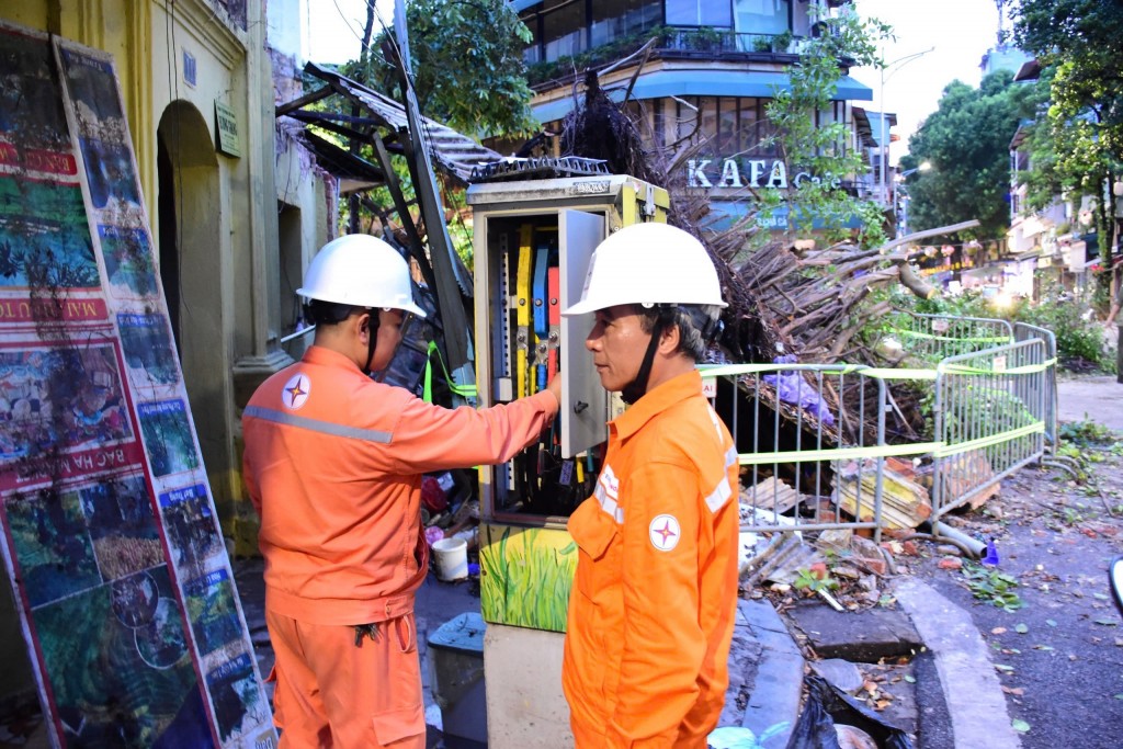 Tại khu vực nút giao phố Hàng Cá - Chả Cá (quận Hoàn Kiếm), một cây cổ thụ bị đổ chắn ngang đường. Các công nhân EVNHANOI đã lập tức có mặt tại hiện trường để đảm bảo an toàn cho hệ thống điện…