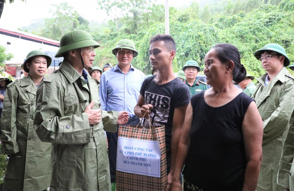 Phó Thủ tướng, Bộ trưởng Bộ Ngoại giao Bùi Thanh Sơn tặng quà gia đình bà Nguyễn Thị Tân, Tổ dân phố 2, thị trấn Thác Bà, là hộ dân di dời từ ngày 08/8/2024 và phải thuê nhà ở cho đến nay. Gia đình hiện không có diện tích đất nào khác trên địa bàn thị trấn Thác Bà. - Ảnh: VGP/Minh Ngọc