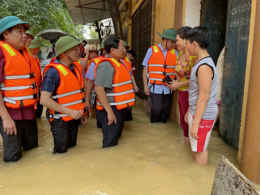 Thủ tướng Phạm Minh Chính trực tiếp vào khu dân cư thăm hỏi, động viên người dân tại xã Vân Hà, thị xã Việt Yên đang bị cô lập - Ảnh: VGP/Nhật Bắc