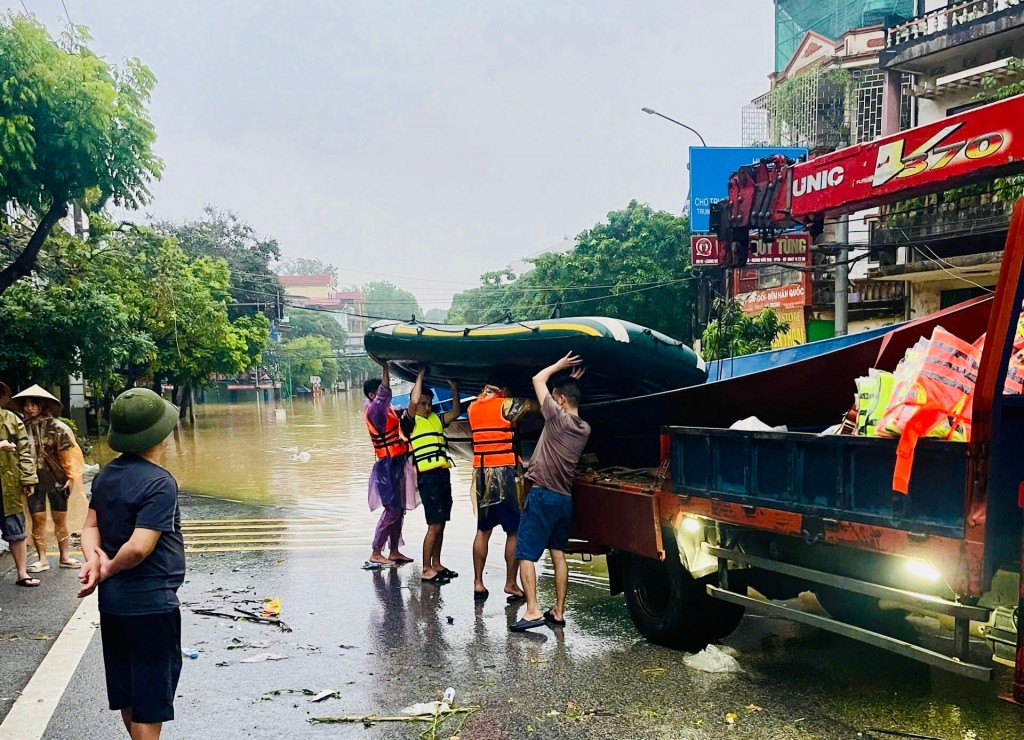 Bà con Nhân dân xã Hương Sơn, huyện Mỹ Đức vận chuyển thuyền, đò và nhu yếu phẩm lên hỗ trợ Nhân dân vùng lũ