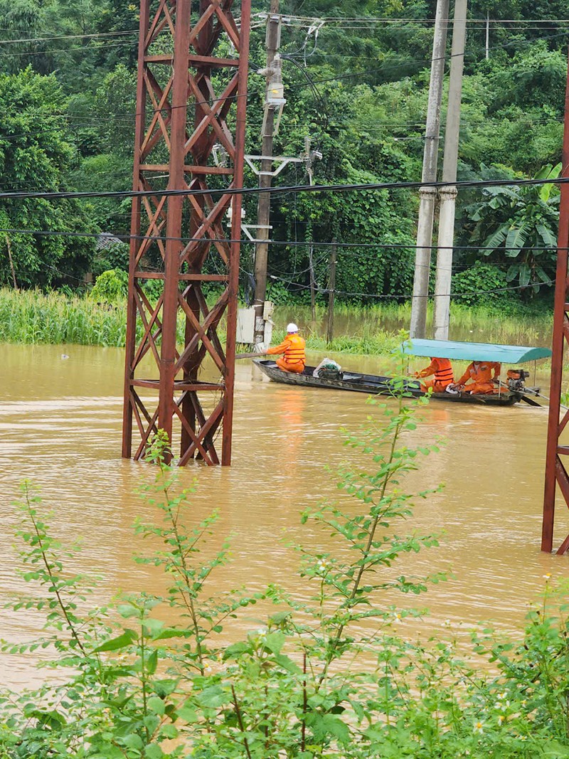 Công nhân Điện lực Na Hang đi thuyền kiểm tra hiện trường sau khi nước lũ dâng cao