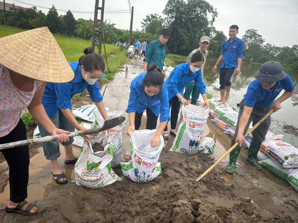 Đoàn viên thanh niên ở cá địa bàn hỗ trợ người dân vùng bị ngập lụt