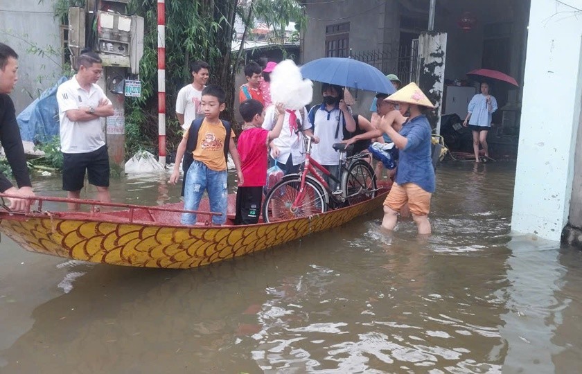 Lực lượng chức năng cùng phụ huynh dùng thuyền đưa học sinh đến trường