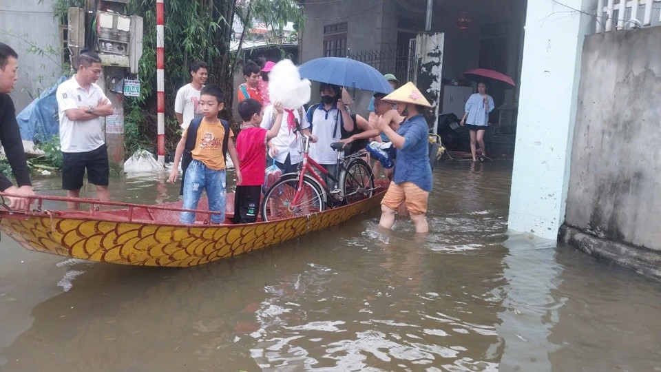 Lực lượng chức năng cùng phụ huynh dùng thuyền đưa học sinh đến trường