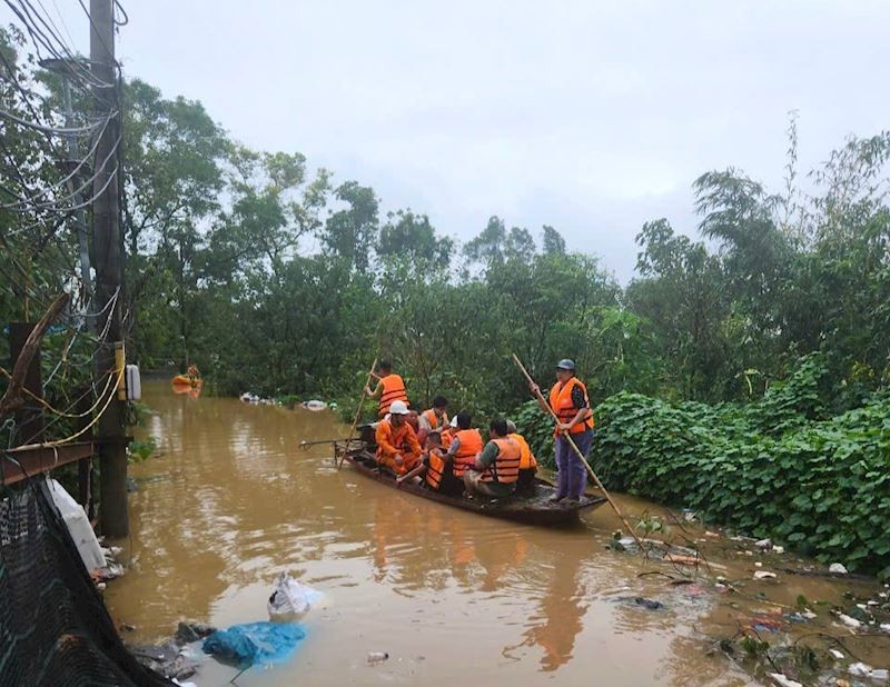 Công nhân EVNHANOI phối hợp cùng lực lượng chức năng di tản người dân khỏi vùng ngập úng