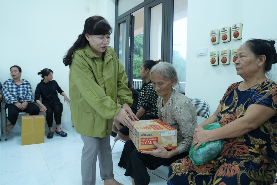Trưởng ban Tuyên giáo Quận uỷ Tây Hồ Trần Thị Thu Hường động viên và tặng quà người cao tuổi tại nơi tránh lũ