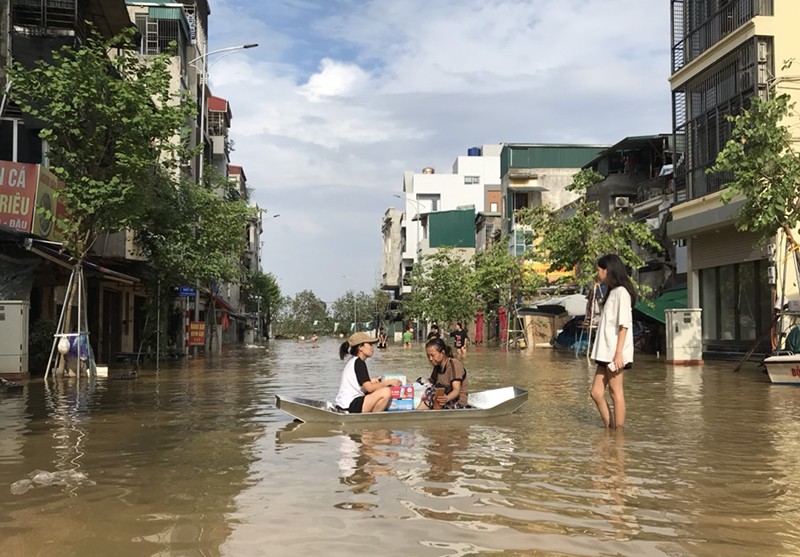 Nhu yếu phẩm được cho vào thuyền đẩy đến các hộ dân nằm sâu trong các ngõ phố bị lũ chia cắt