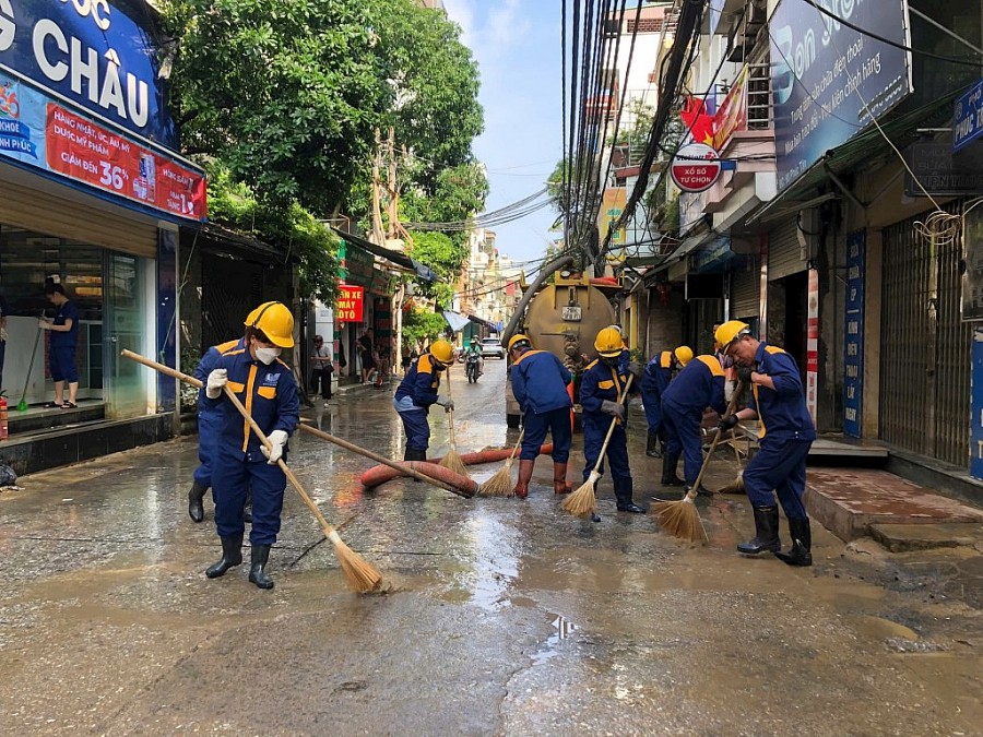 Công nhân thoát nước giúp người dân rửa đường, quét dọn vệ sinh trên phố Phúc Tân. Ảnh: Uyên Hoàng.