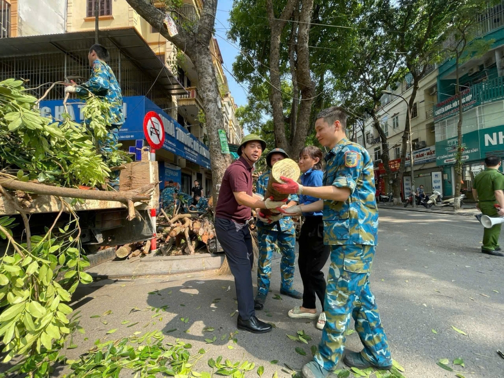 Chủ tịch UBND quận Hoàng Mai Nguyễn Minh Tâm cùng lực lượng vũ trang quân đội, đoàn thanh niên phường Định công thu dọn cây xanh đổ do bão