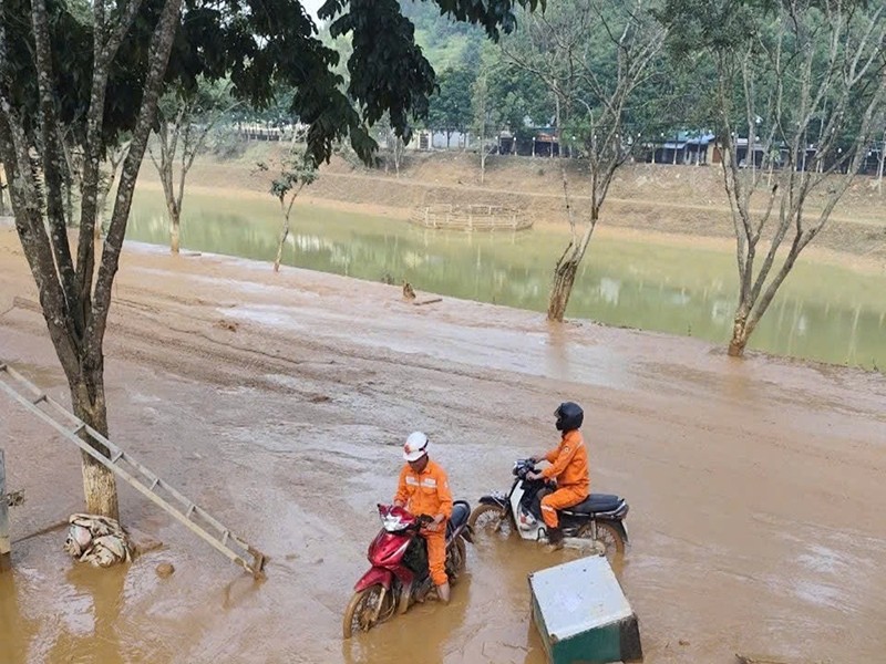 Công nhân Điện lực Bắc Hà, PC Lào Cai vượt qua bùn đất để khắc phục sự cố sau mưa bão