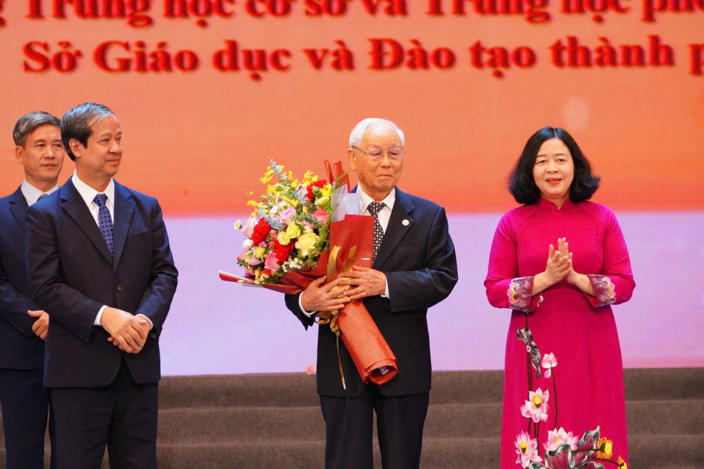 Đồng chí Bùi Thị Minh Hoài - Ủy viên Bộ Chính trị, Bí thư Thành ủy, Trưởng đoàn Đại biểu Quốc hội TP Hà Nội và Bộ trưởng Bộ GD&ĐT Nguyễn Kim Sơn chúc mừng nhà giáo được phong tặng danh hiệu Nhà giáo ưu tú