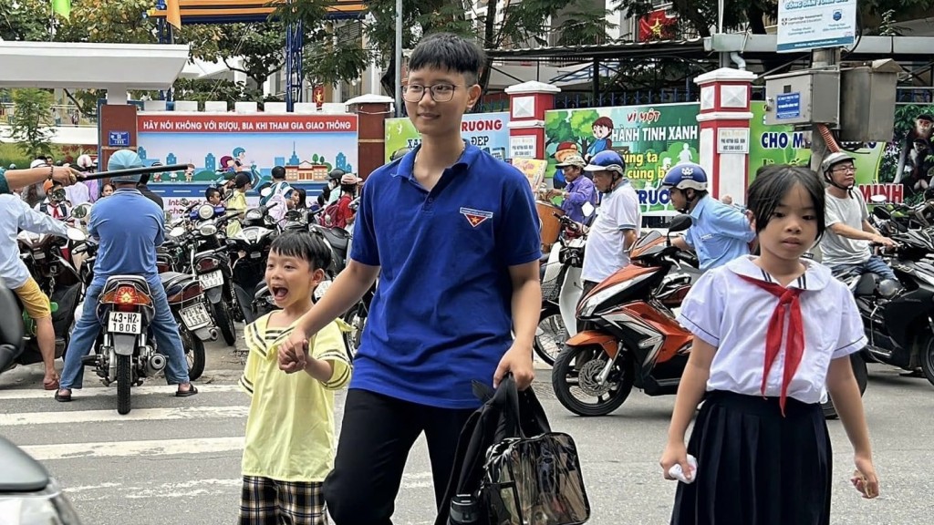 Các đoàn viên thanh niên phân luồng cho học sinh băng qua đường theo hàng lối 