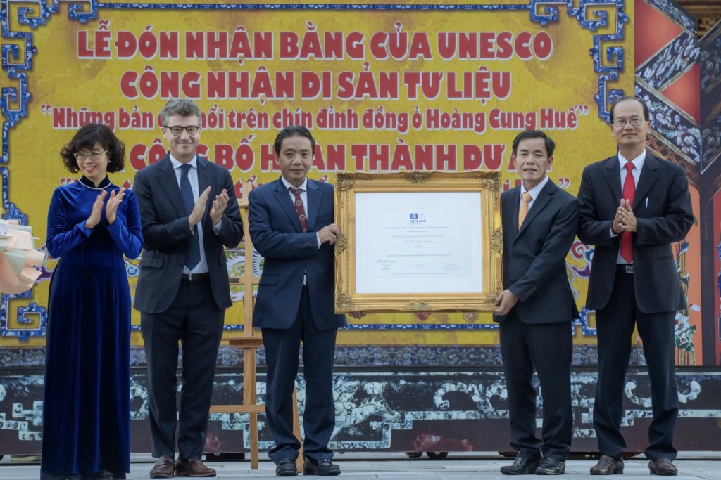 Đại diện lãnh đạo Bộ Văn hóa, TT&DL và UBND tỉnh Thừa Thiên - Huế đón nhận bằng UNESCO công nhận Di sản tư liệu “Những bản đúc nổi trên chín đỉnh đồng ở Hoàng Cung Huế”