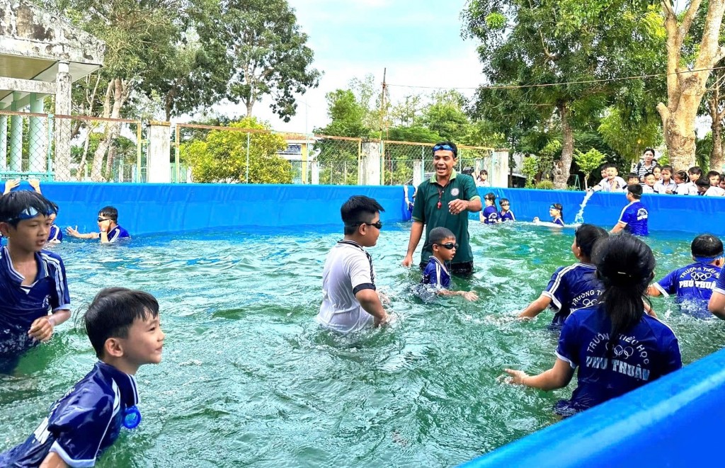 Thầy trò Trường tiểu học Phú Thuận tập bơi trong chiếc hồ mới do Quỹ Phát triển Tài năng Việt trao tặng.