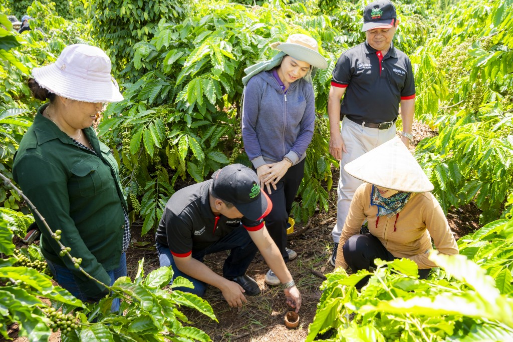 Cán bộ hỗ trợ nông nghiệp của Nestlé Việt Nam hướng dẫn nông dân trồng cà phê thực hành canh tác nông nghiệp tái sinh