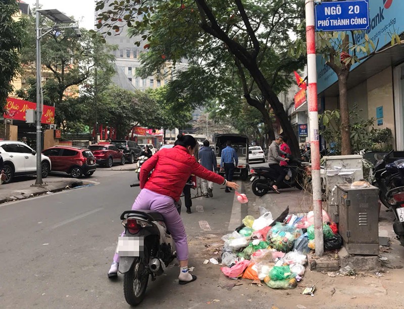 Cách đó không xa, một phụ nữ ngồi trên xe máy cũng vô tư ném túi rác ở ngõ 20 phố Thành Công