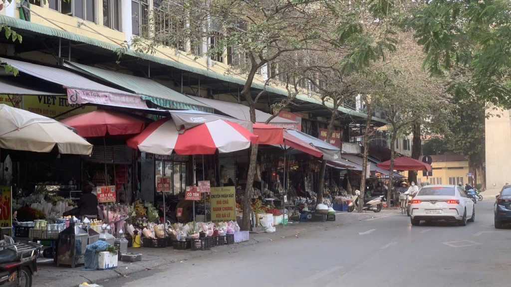 Tiểu thương chợ Cầu Giấy tràn từ trong chợ ra bên ngoài đường Nguyễn Khang để bày bán thực phẩm, đồ dùng hàng ngày.