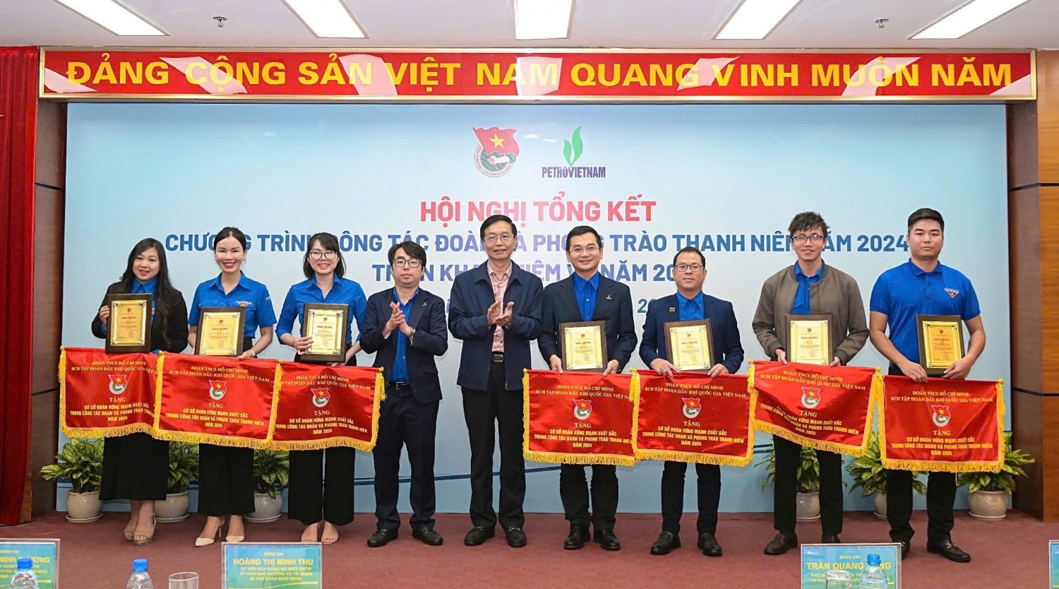 Đồng chí Trần Quang Dũng và đồng chí Phạm Đăng An trao biểu trưng và Cờ thi đua cho đại diện các cơ sở Đoàn vững mạnh, xuất sắc trong công tác Đoàn và phong trào thanh niên năm 2024
