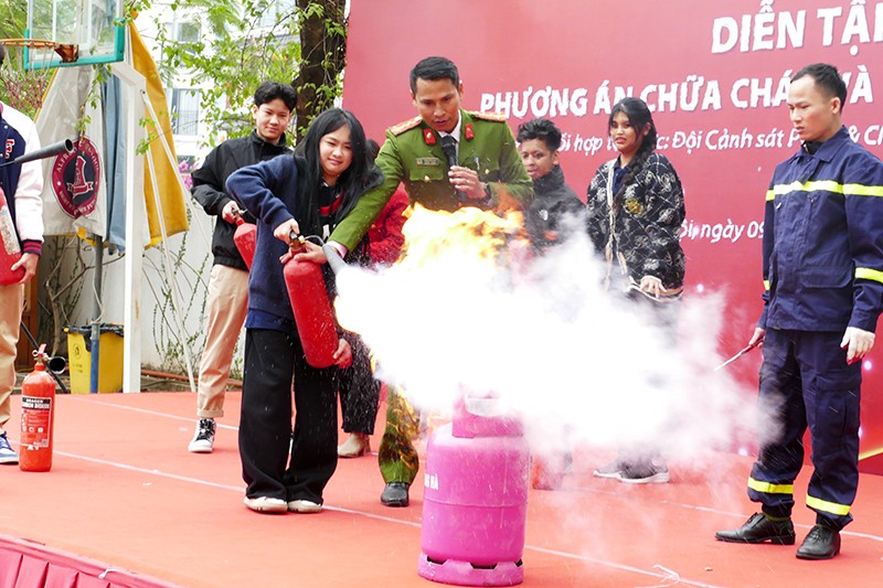 Đại uý Trần Văn Khả hướng dẫn các em học sinh sử dụng bình cứu hoả dập lửa