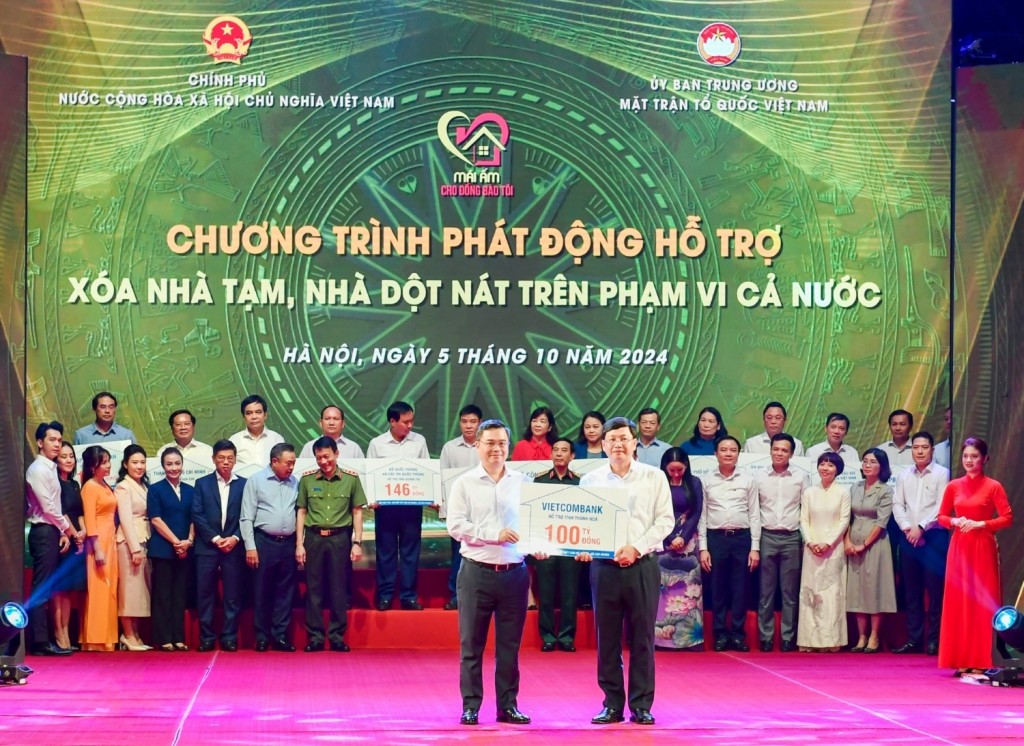 Ông Nguyễn Thanh Tùng (bên trái) - Bí thư Đảng ủy, Chủ tịch HĐQT Vietcombank trao tượng trưng kinh phí 100 tỷ đồng hỗ trợ xoá nhà tạm, nhà dột nát ủng hộ cho địa phương