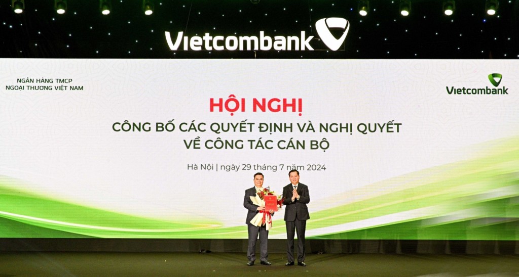 Ông Nguyễn Long Hải - Ủy viên dự khuyết BCH Trung ương Đảng, Bí thư Đảng ủy Khối DNTW (bên phải) trao Quyết định và tặng hoa chúc mừng đ/c Nguyễn Thanh Tùng, tân Bí thư Đảng ủy, Chủ tịch HĐQT Vietcombank