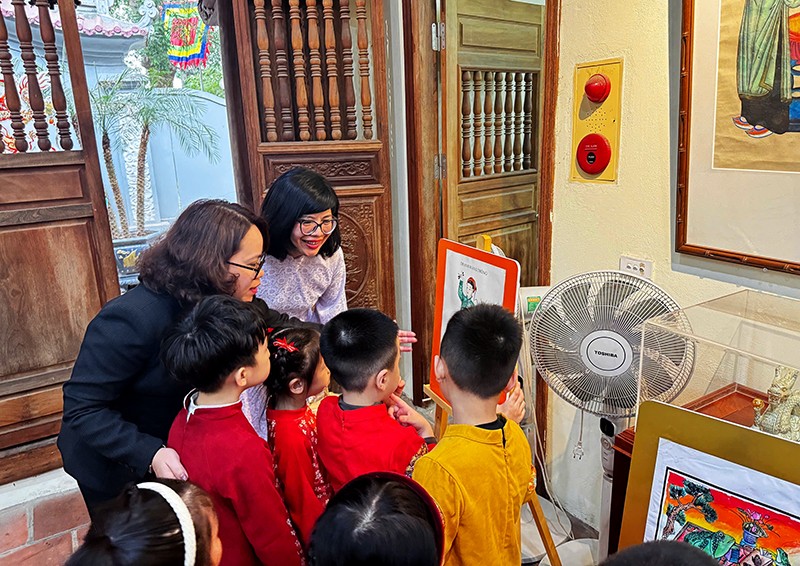 Trưởng phòng Giáo dục và Đào tạo quận Hoàn Kiếm Trịnh Ngọc Trâm hướng dẫn các em học sinh hiểu rõ ý nghĩa, lịch sử của những bức tranh 