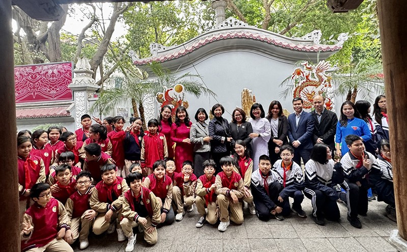 Các đại biểu chụp ảnh lưu niệm với các em học sinh tại Triển lãm Tranh Hàng Trống - Sắc màu Tết của trẻ