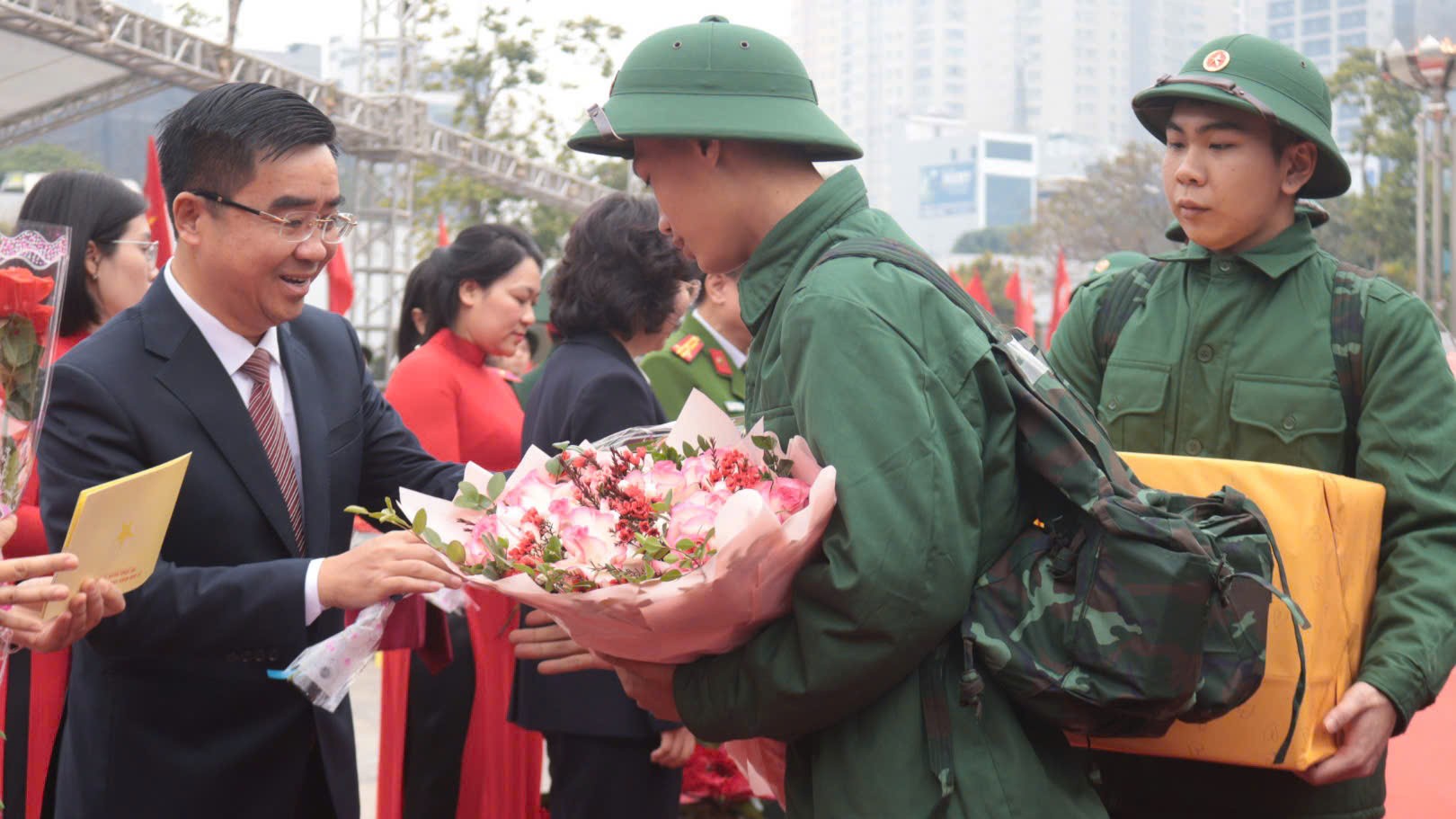 Đồng chí Bùi Huyền Mai, Uỷ viên Ban Thường vụ Thành ủy, Bí thư quận ủy Thanh Xuân và Võ Đăng Dũng, Phó Bí thư Quận ủy, Chủ tịch UBND quận, Chủ tịch Hội đồng nghĩa vụ quân sự quận tặng hoa cho các tân binh trước khi lên xe về đơn vị.